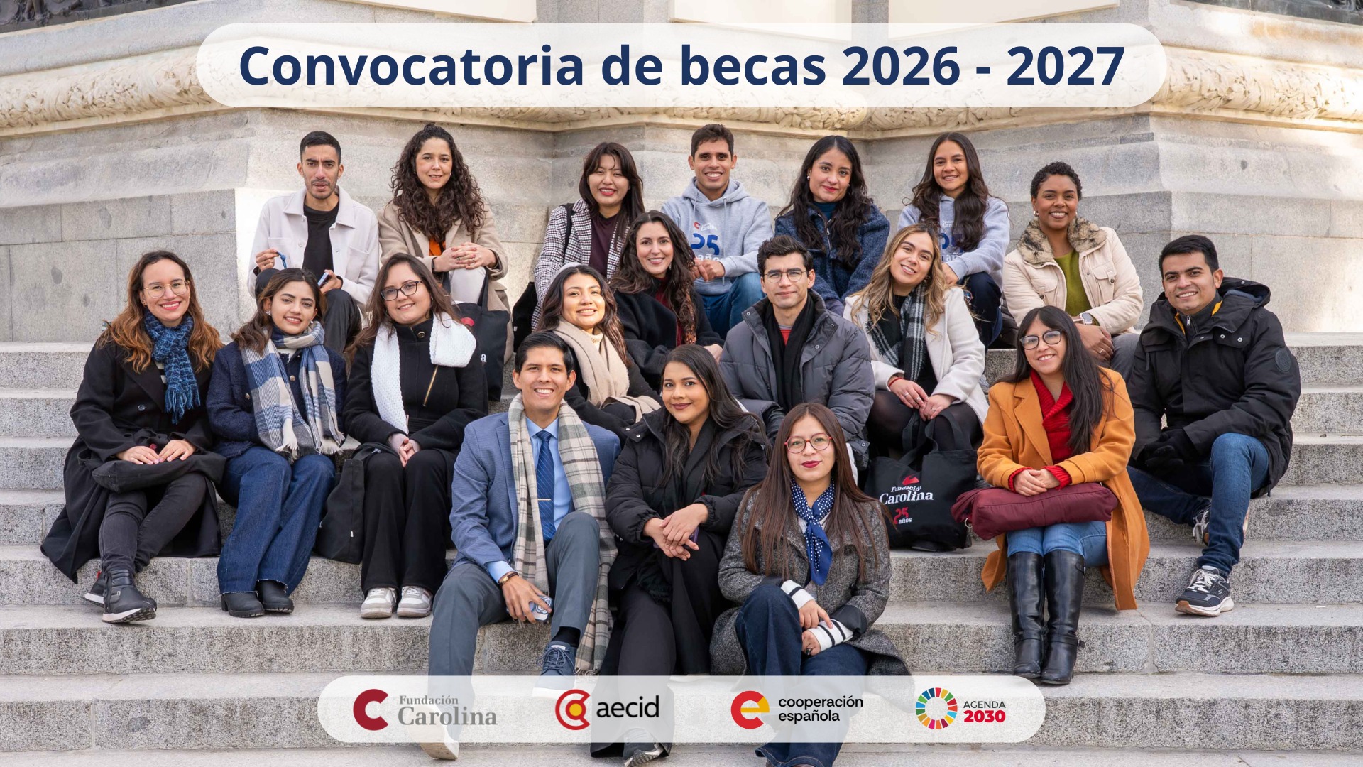 Cartel de la Convocatoria de becas 2026-2027 que muestra a un grupo de jóvenes sentados en unas gradas. Incluye los logotipos de la Fundación Carolina, AECID, Cooperación Española y la Agenda 2030. 