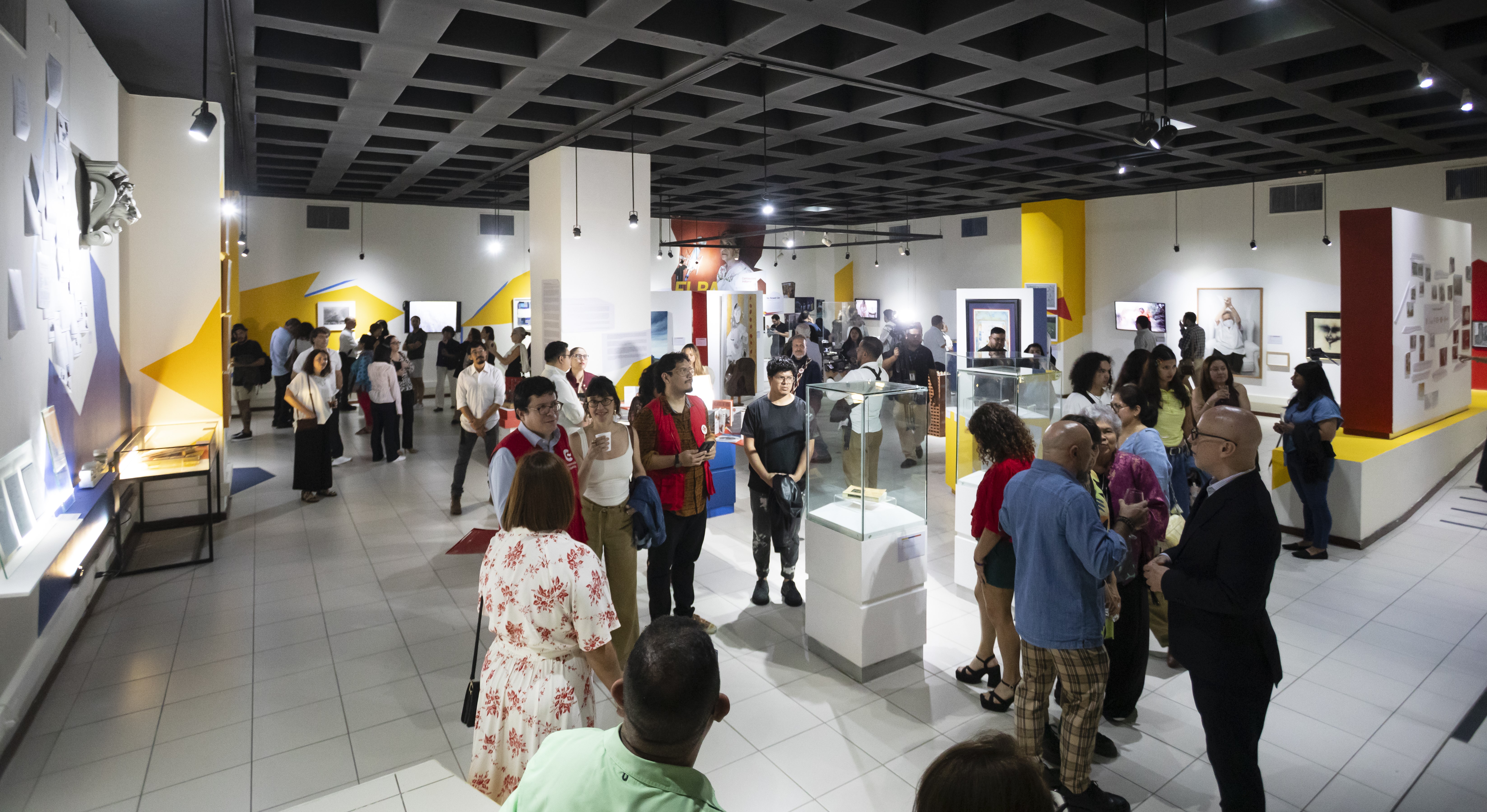 Grupos diversos de personas visitan la exposición "Cooperación ES Cultura" durante su inauguración
