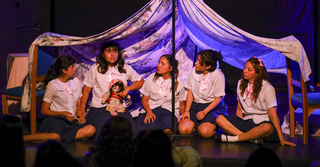 Una escena de la obra «Hojitas de laurel» en la que cinco actrices hacen de niñas bajo una tiendita o carpa.