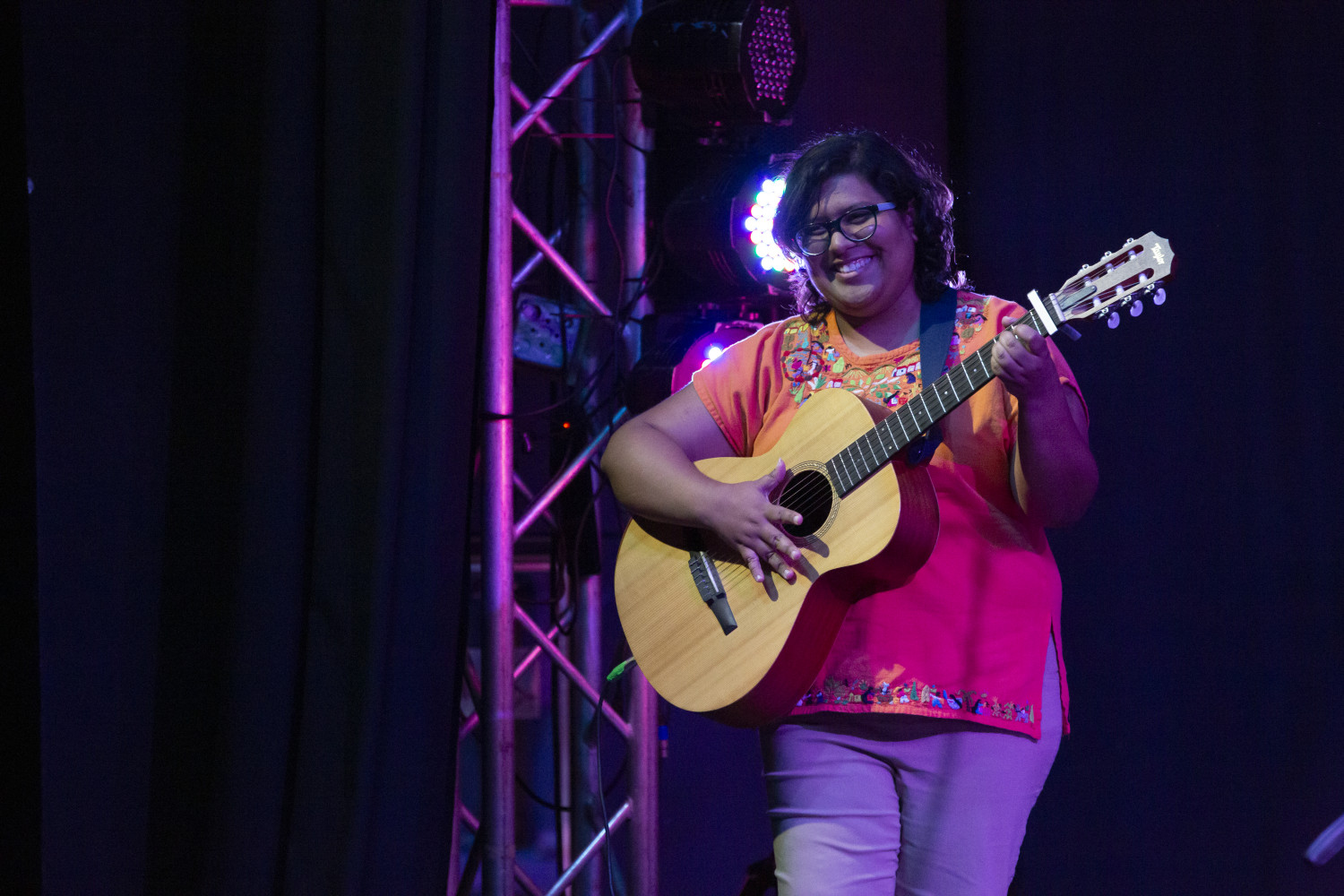 Mujer en el escenario tocando la guitarra