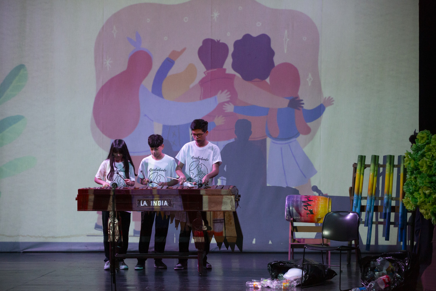 Dos niños y una niña tocando instrumento