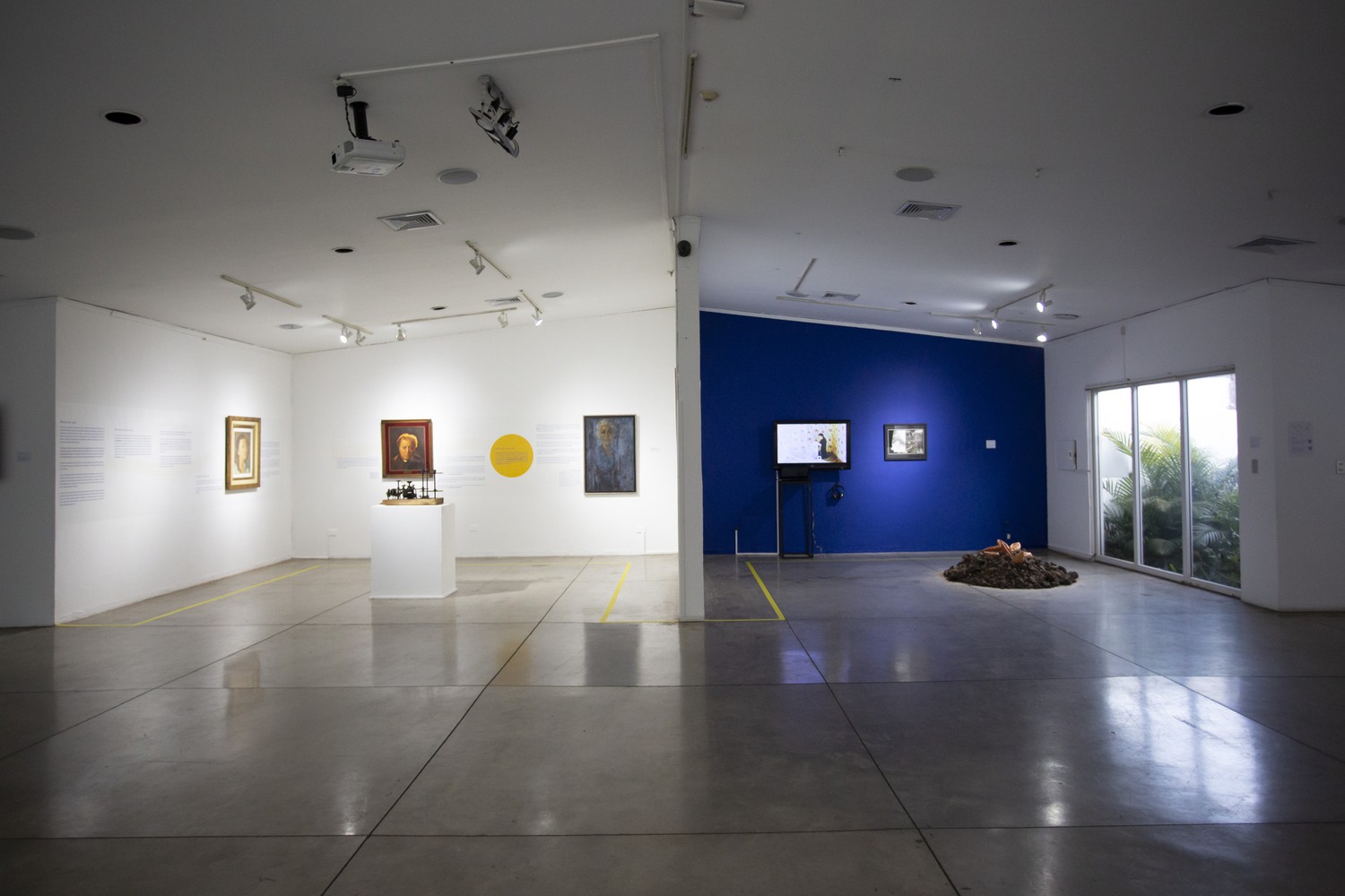 Sala de exposiciones son mitad de pared blanca y mitad pared azul oscuro