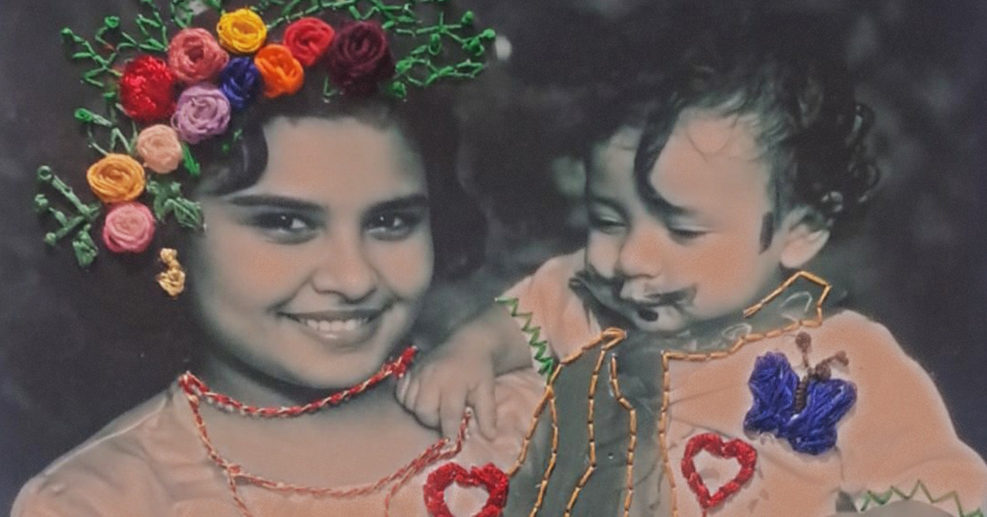 Una fotografía antigua de una joven y un niño pequeño, bordada con flores, corazones y mariposas